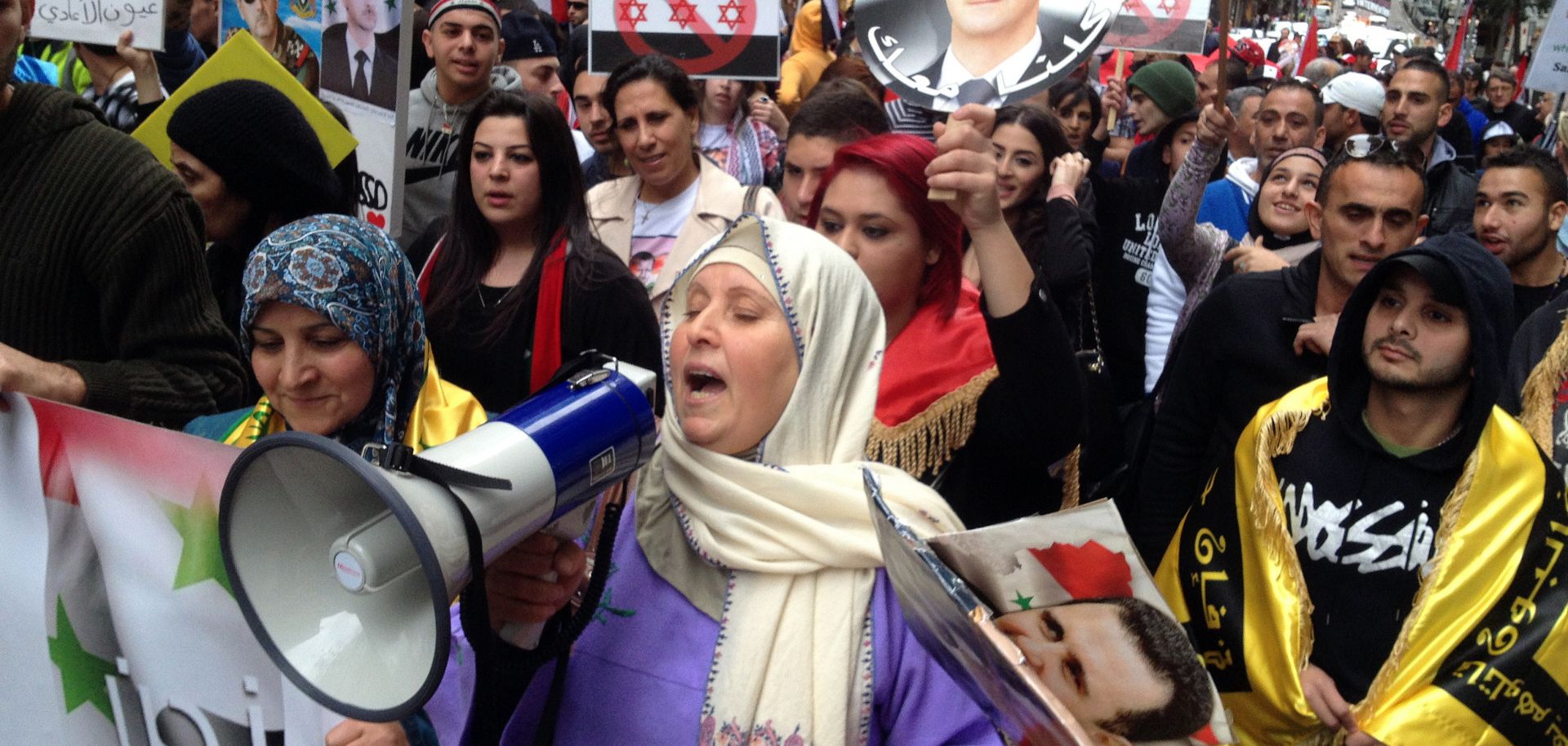 Syrians living in Australia shout slogans in support of Syrian President Bashar al-Asad protest rally on June 15, 2013.