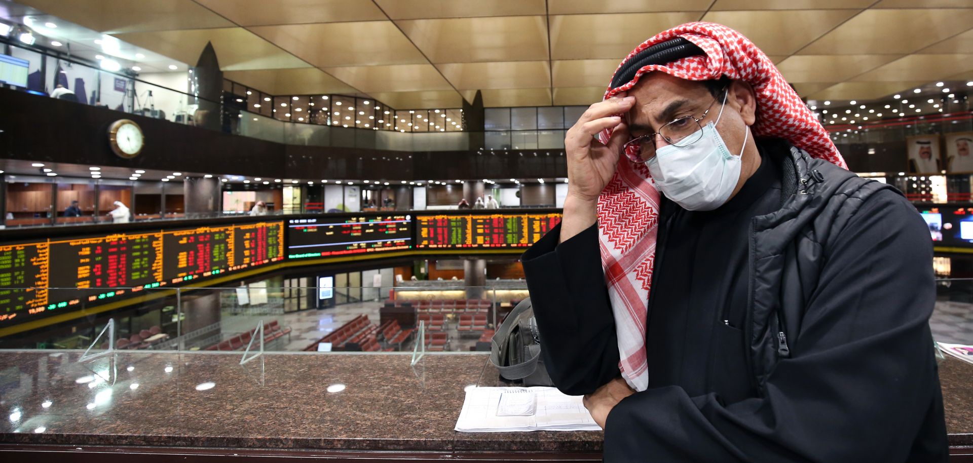 A trader wearing a protective mask stands on the floor of the Boursa Kuwait stock exchange in Kuwait City, Kuwait, on March 1, 2020.