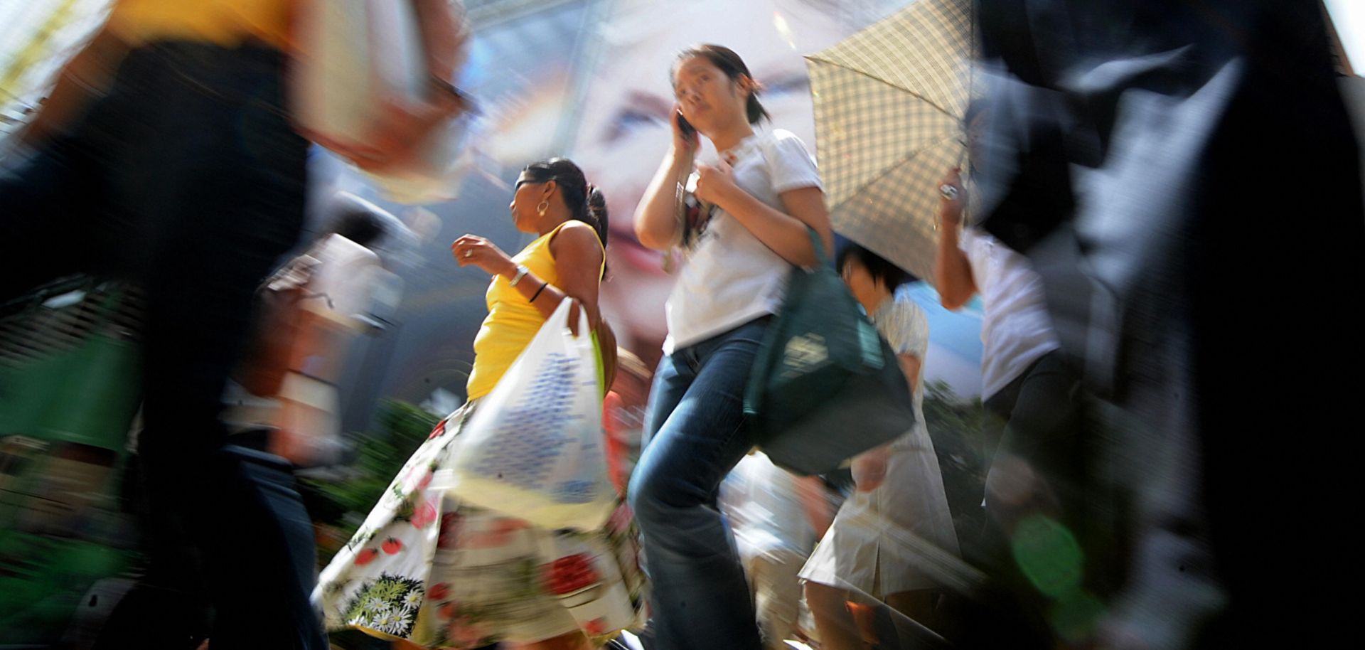 Shoppers cross the street in a busy retail area in Hong Kong on July 2, 2009.