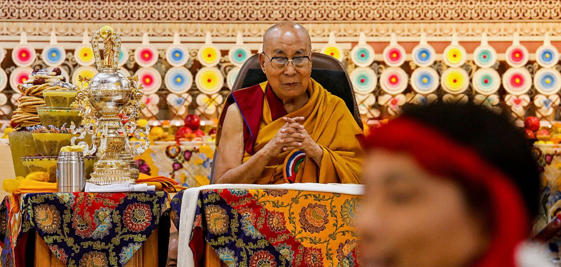 Tibetan spiritual leader the Dalai Lama looks on as offerings presented by Buddhist followers are laid on a table during a Long Life Prayer offering ceremony at the Main Tibetan Temple in McLeod Ganj, near the Indian city of Dharamshala, on June 30, 2025. 