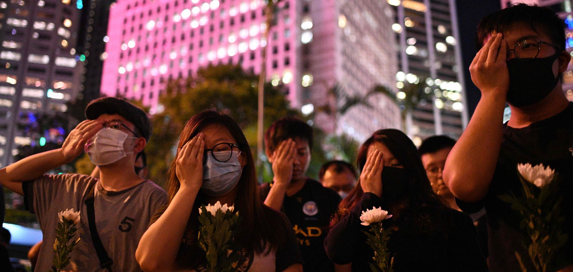 Protesters cover their right eyes as they attend the Stand in Silence for the 74th Anniversary of the Liberation of Hong Kong event at the cenotaph in Hong Kong on Aug. 30, 2019.