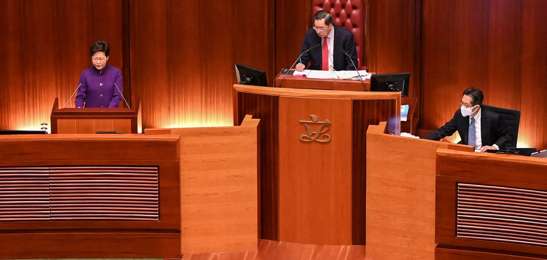 The president of Hong Kong’s Legislative Council, Andrew Leung (center), looks on as Chief Executive Carrie Lam (left) makes an address during the first session of the newly elected legislature on Jan. 12, 2022.