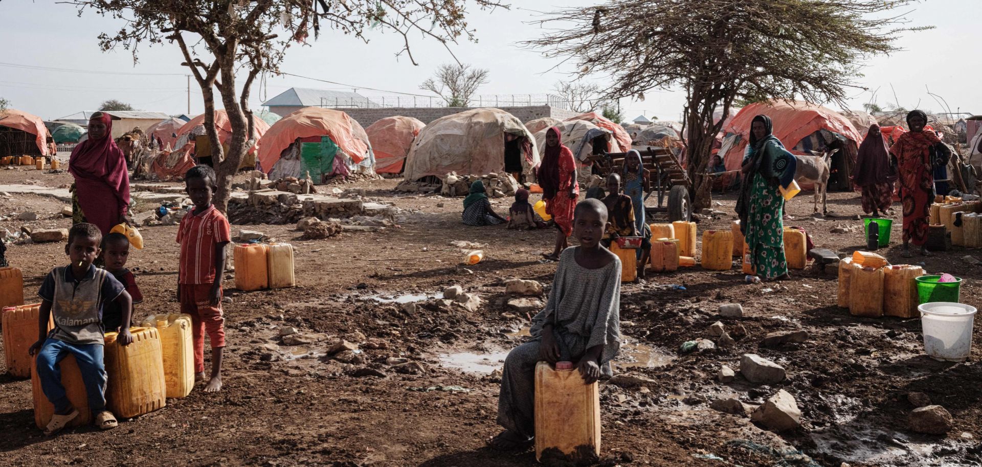 People wait for water with containers at a camp for internally displaced persons (IDPs) in Baidoa, Somalia, on Feb. 13, 2022. 