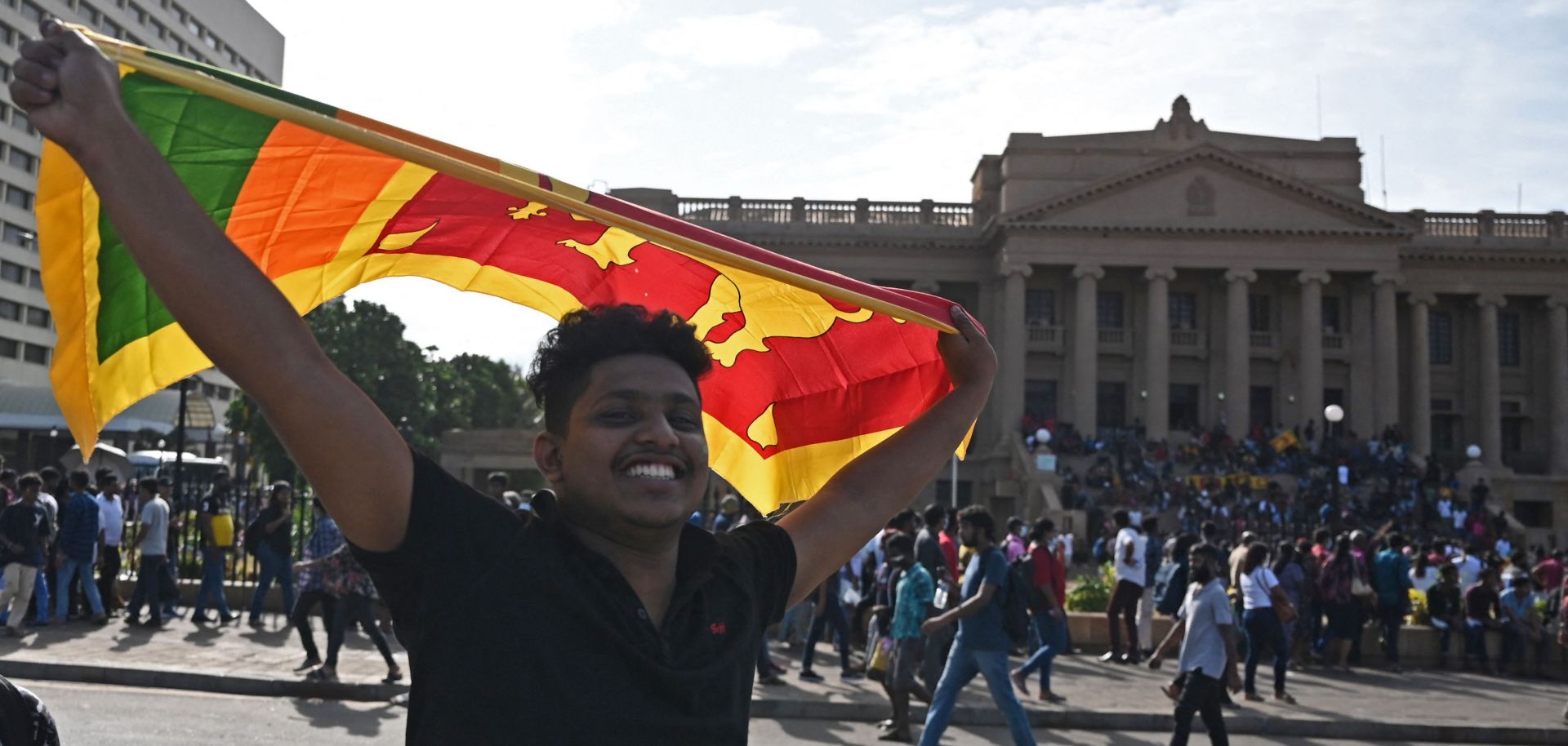 A protester waves Sri Lanka's national flag outside the presidential palace in Colombo on July 13, 2022. 