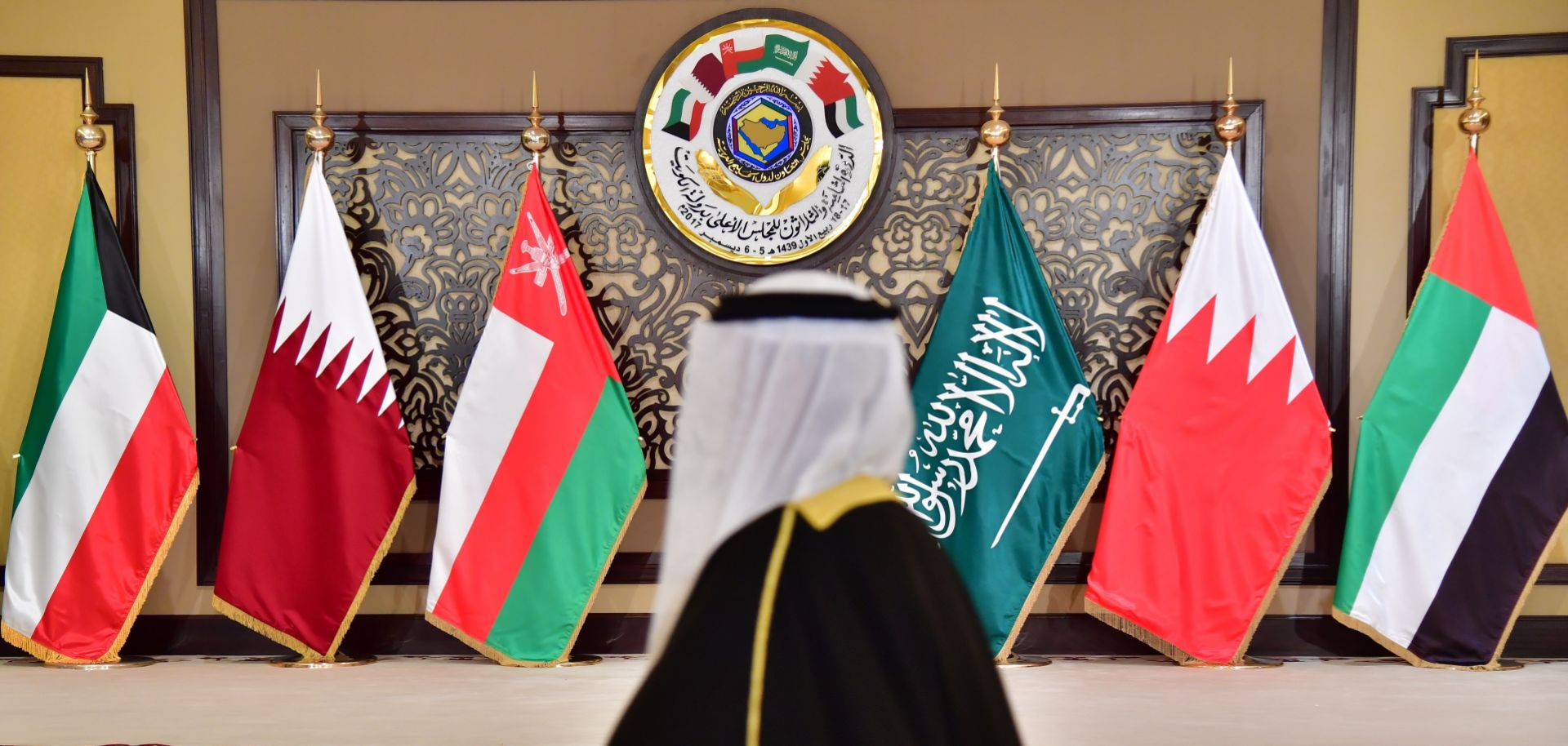 A man walks past the flags of the countries attending the Gulf Cooperation Council (GCC) summit in Kuwait City, Kuwait, on Dec. 5, 2017. 