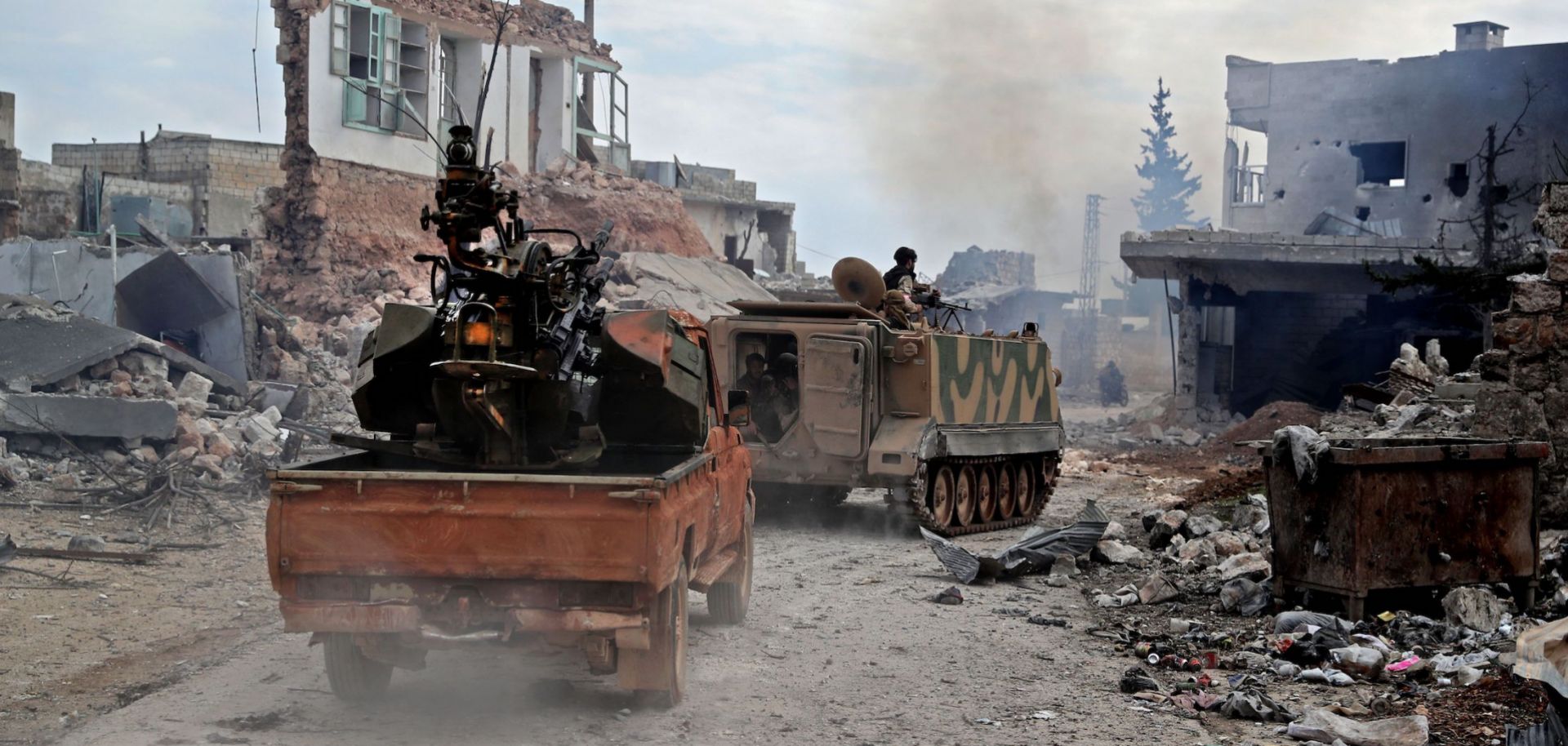 Members of the Syrian National Army, an alliance of rebel groups backed by Turkey, ride in the town of Sarmin, about 8 kilometers (5 miles) southeast of the city of Idlib in northwestern Syria, on Feb. 24, 2020.