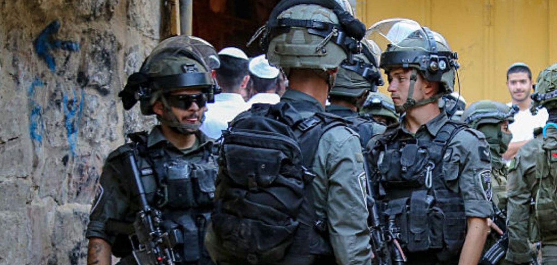 A group of armed Israeli soldiers stands in a narrow alley of the Old City of Hebron, West Bank, on May 31, 2025. 