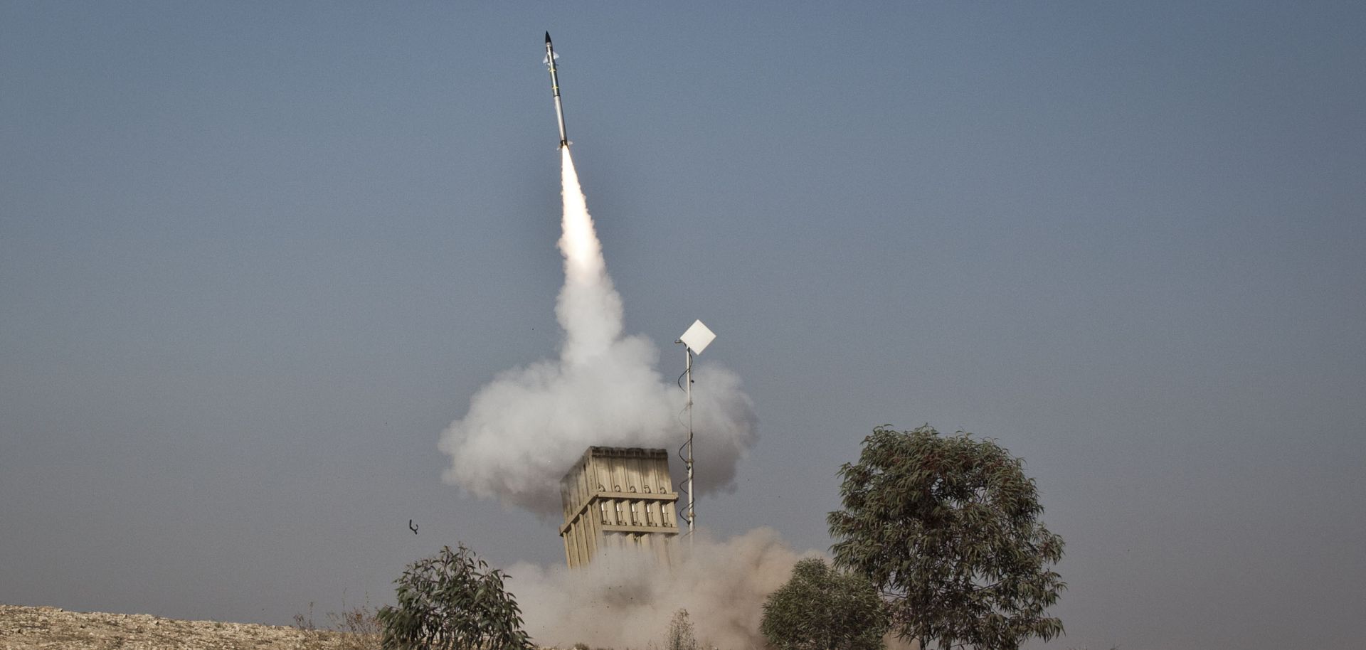 An Israeli soldier lies on the ground as missiles are fired from an Iron Dome anti-missile station on November 15, 2012 near the city of Beer Sheva, Israel.