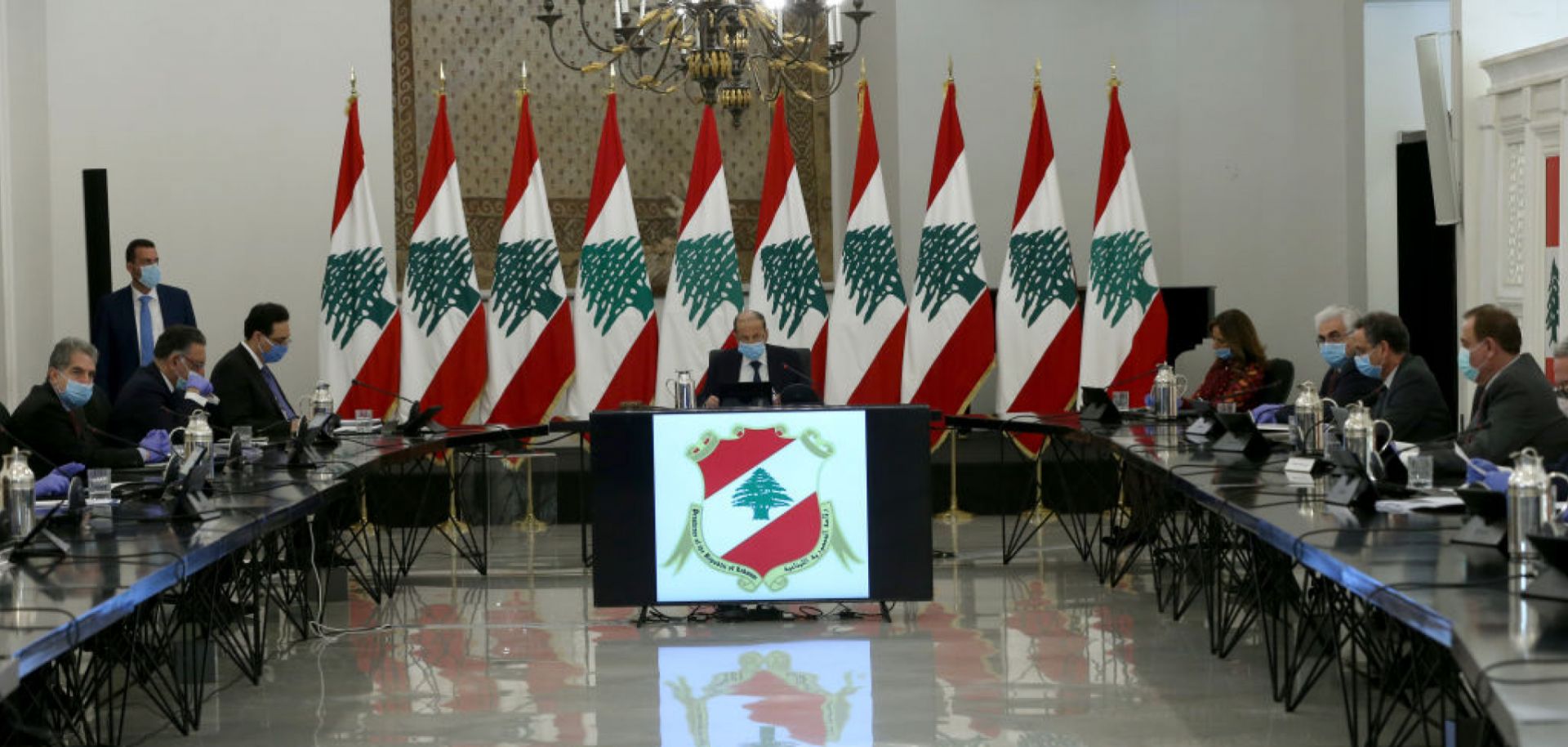 Lebanese President Michel Aoun (C) wears a face mask as a preventive measure against COVID-19 during a March 26, 2020, meeting in Beirut to evaluate measures taken against the virus' spread.