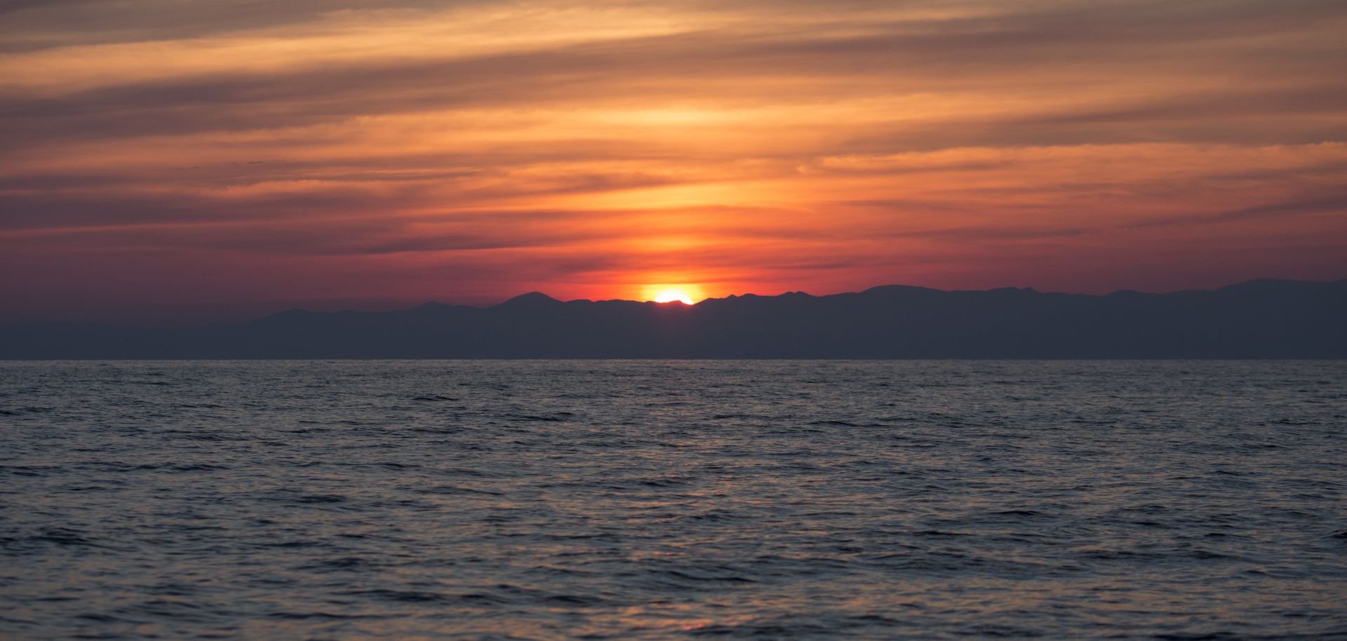 The sun rises over the Turkish coastline as Portuguese Frontex crew monitor the Aegean sea between Turkey and Greece for boats carrying refugees on March 30, 2016 near Mithymna, Greece. 