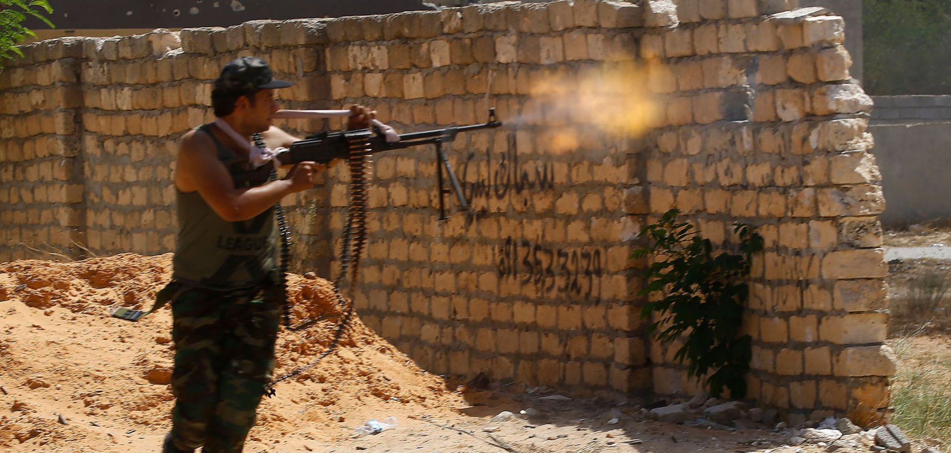 A fighter loyal to Libya's internationally recognized government in Tripoli fires on forces allied with Khalifa Hifter's Libyan National Army during clashes in Ain Zara on Sept. 7, 2019.