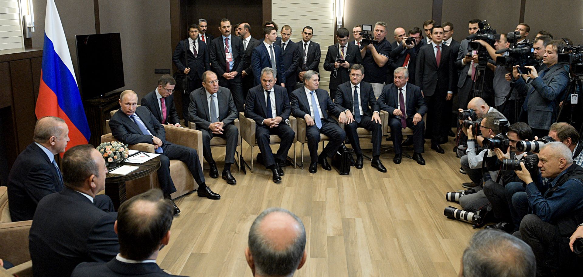 Turkish President Recep Tayyip Erdogan (L) and Russian President Vladimir Putin (in front of flag) sit during a meeting in Sochi to discuss the situation in Syria.