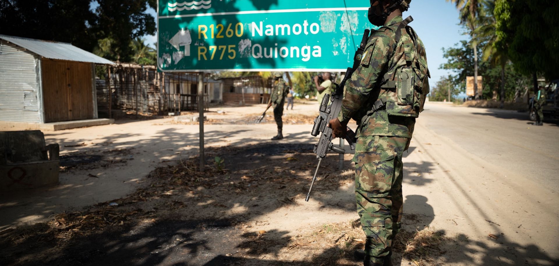 A Rwandan soldier walks in front of a burned truck near Palma in Mozambique’s Cabo Delgado region on Sept. 22, 2021. 