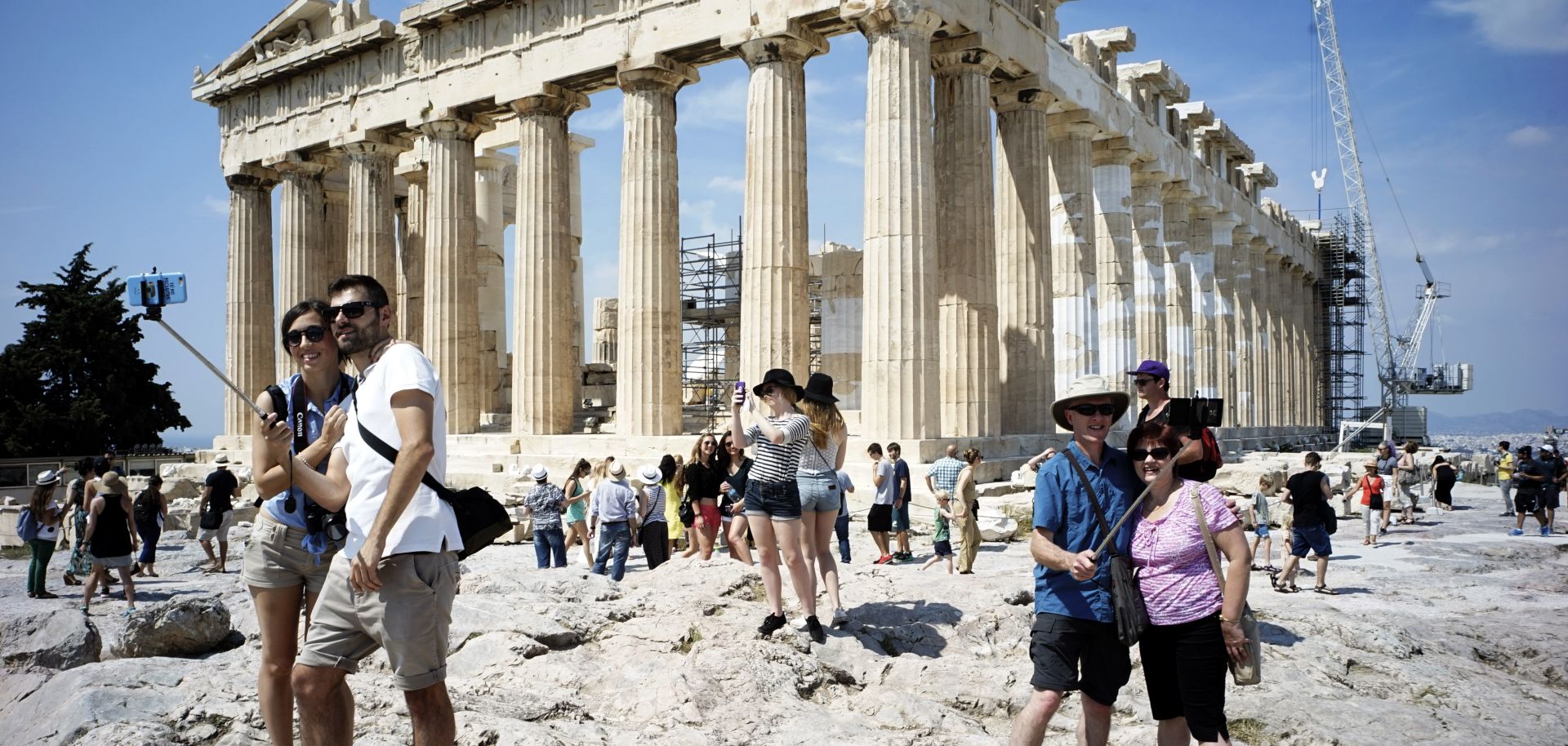 Tourists visit the ancient Acropolis hill, with the ruins of the fifth century BC Parthenon temple on June 30, 2015 in Athens, Greece.