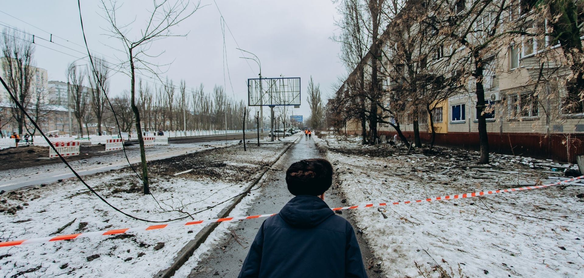 A man looks at the road blocked by striped tape on December 13, 2023, in Kyiv, Ukraine, following two nights of ballistic missile attacks on the city.