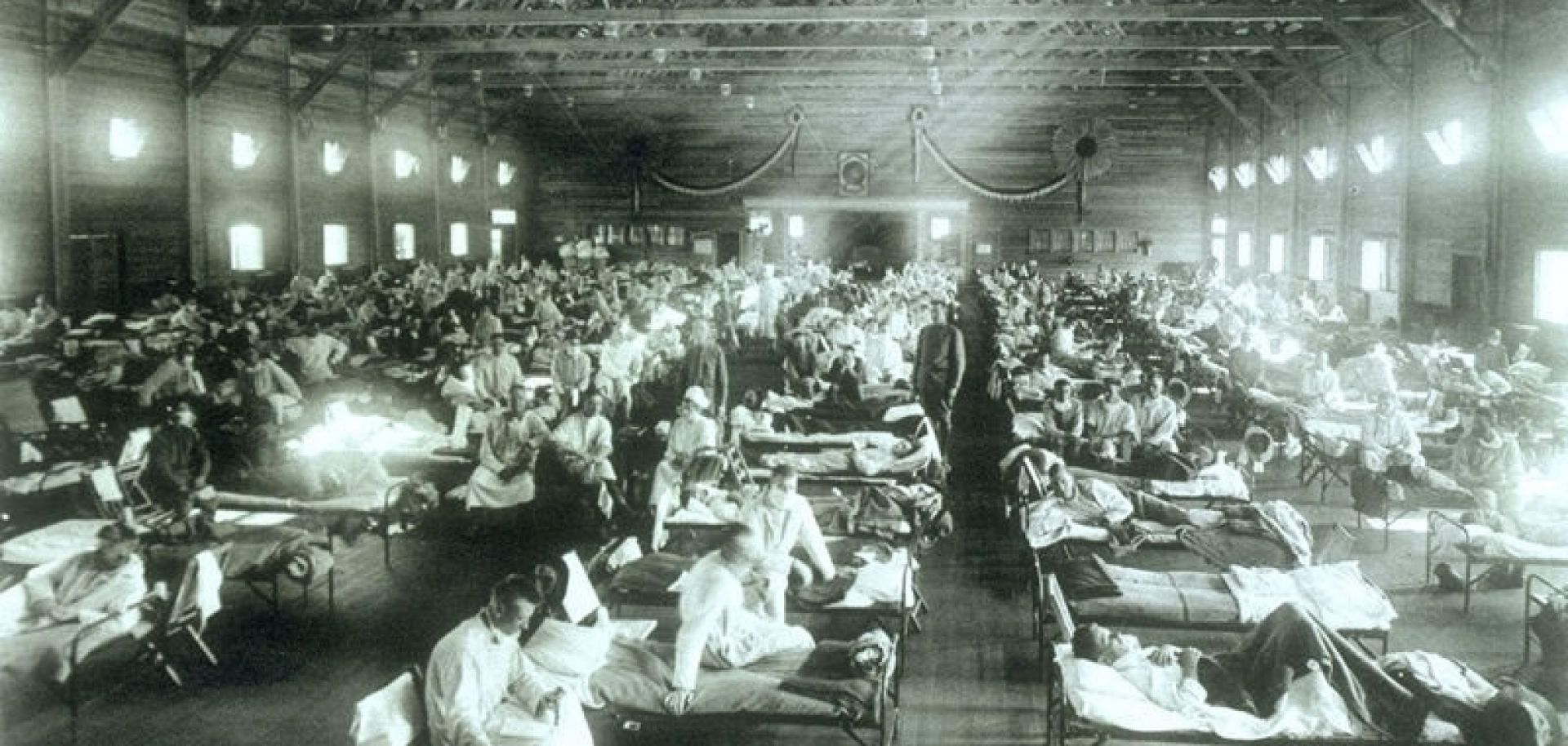 An emergency hospital with rows and rows of sick patients in hospital beds at Camp Funston during the 1918 flu pandemic.