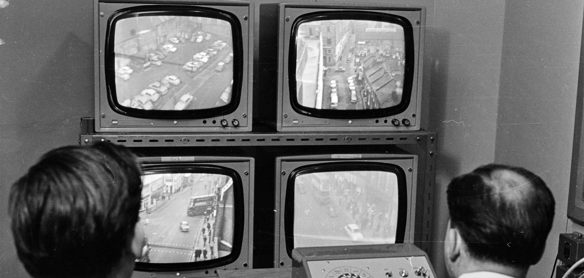 Security men watch police CCTV (closed-circuit television) cameras overlooking a street in Croydon, south London.