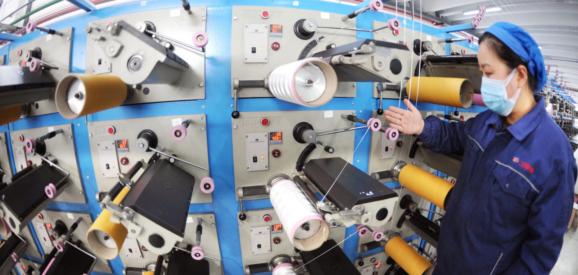 Workers operate a production line of a new material company in Lianyungang, China, on March 23, 2020.