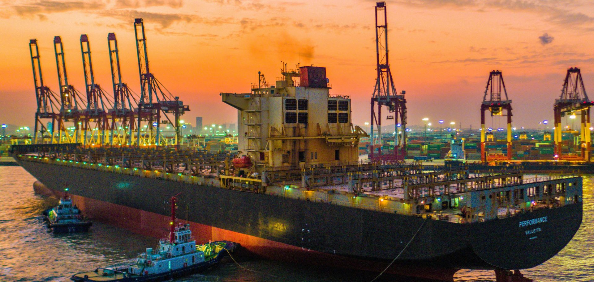 Tugboats push a container ship to the dockyard at a container port in Qingdao, in China's Shandong province, on Sept. 6, 2019.