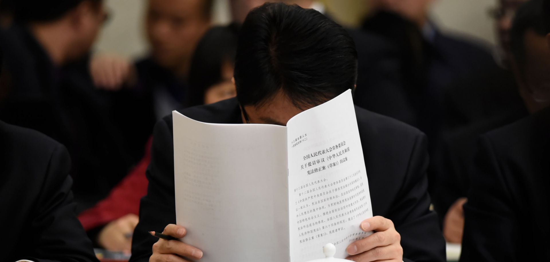 A delegate catches up on some reading during a meeting of the Gansu delegation at the National People's Congress in March 2018.