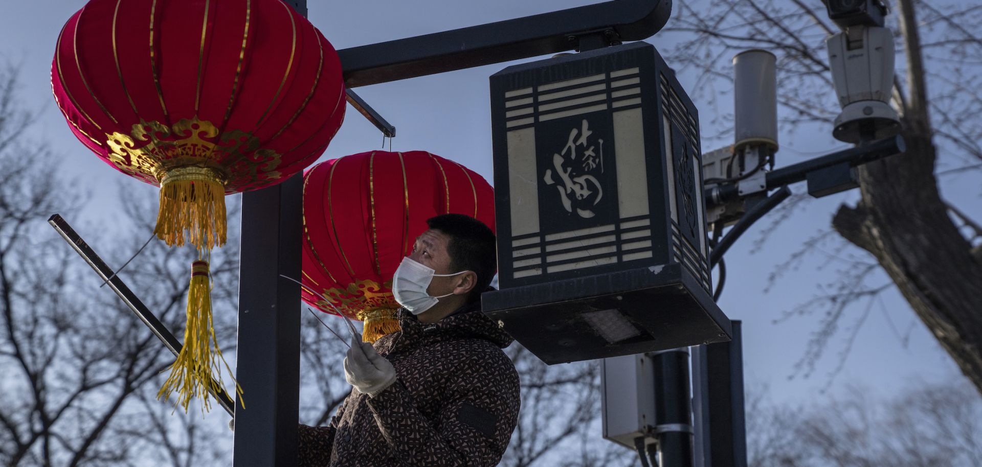 A worker hangs traditional red lanterns for the upcoming Spring Festival on Feb. 3, 2021, in Beijing.