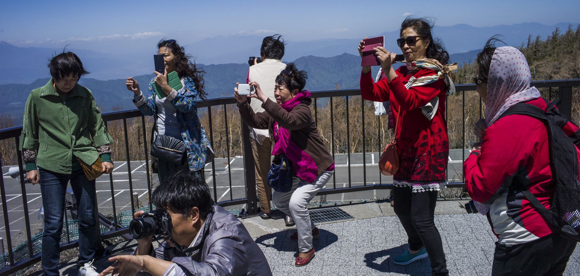 Chinese tourists take photographs at Mount Fuji in Japan.