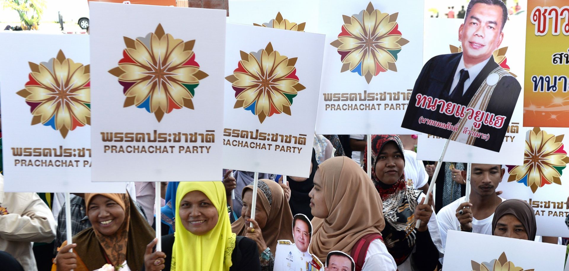 Supporters of the lead pro-military party in Thailand gather outside as the party's candidates arrive to register for country's upcoming election.