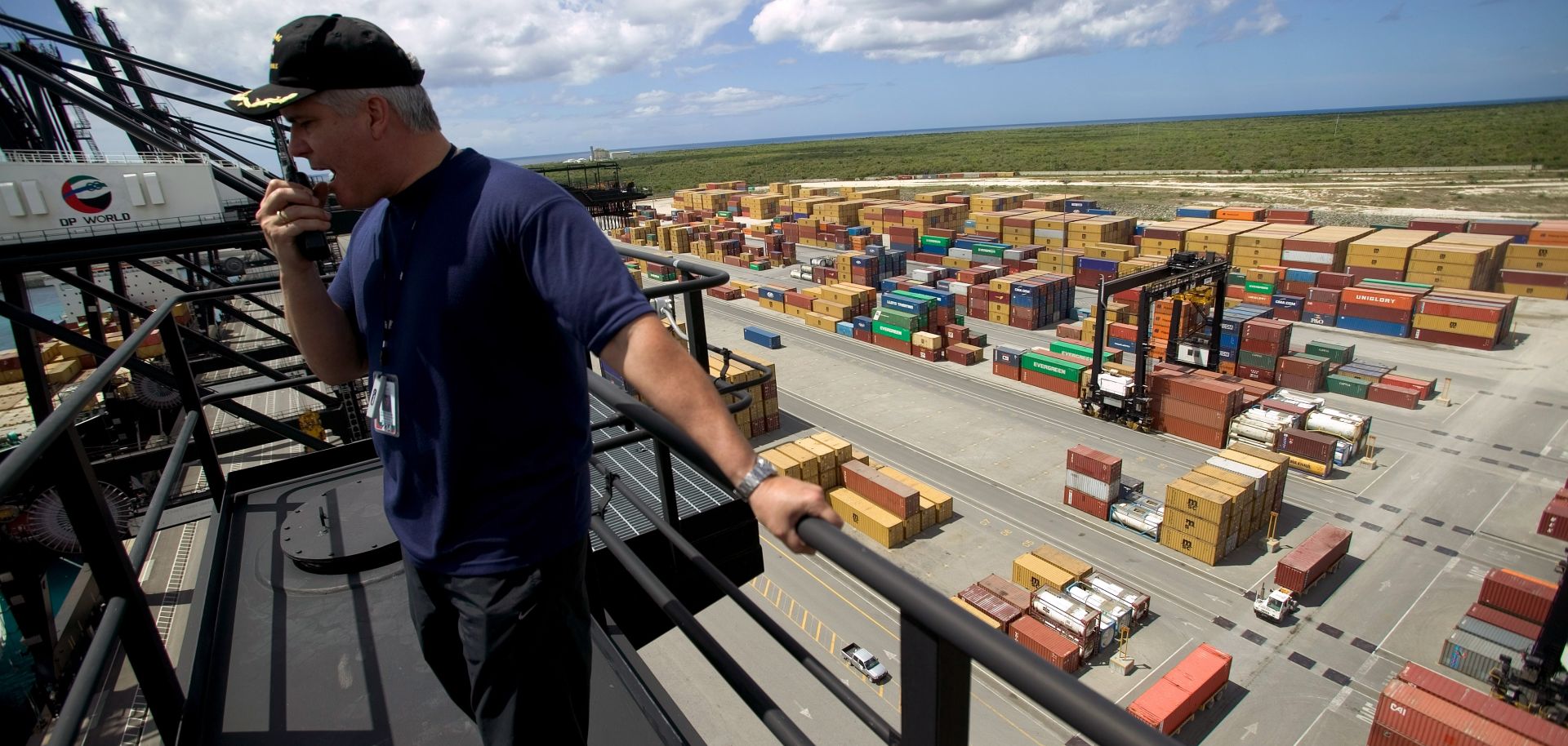 The General Manager of Puerto Caucedo, Ricardo Alvarez, speaks on a walkie talkie above a container port.