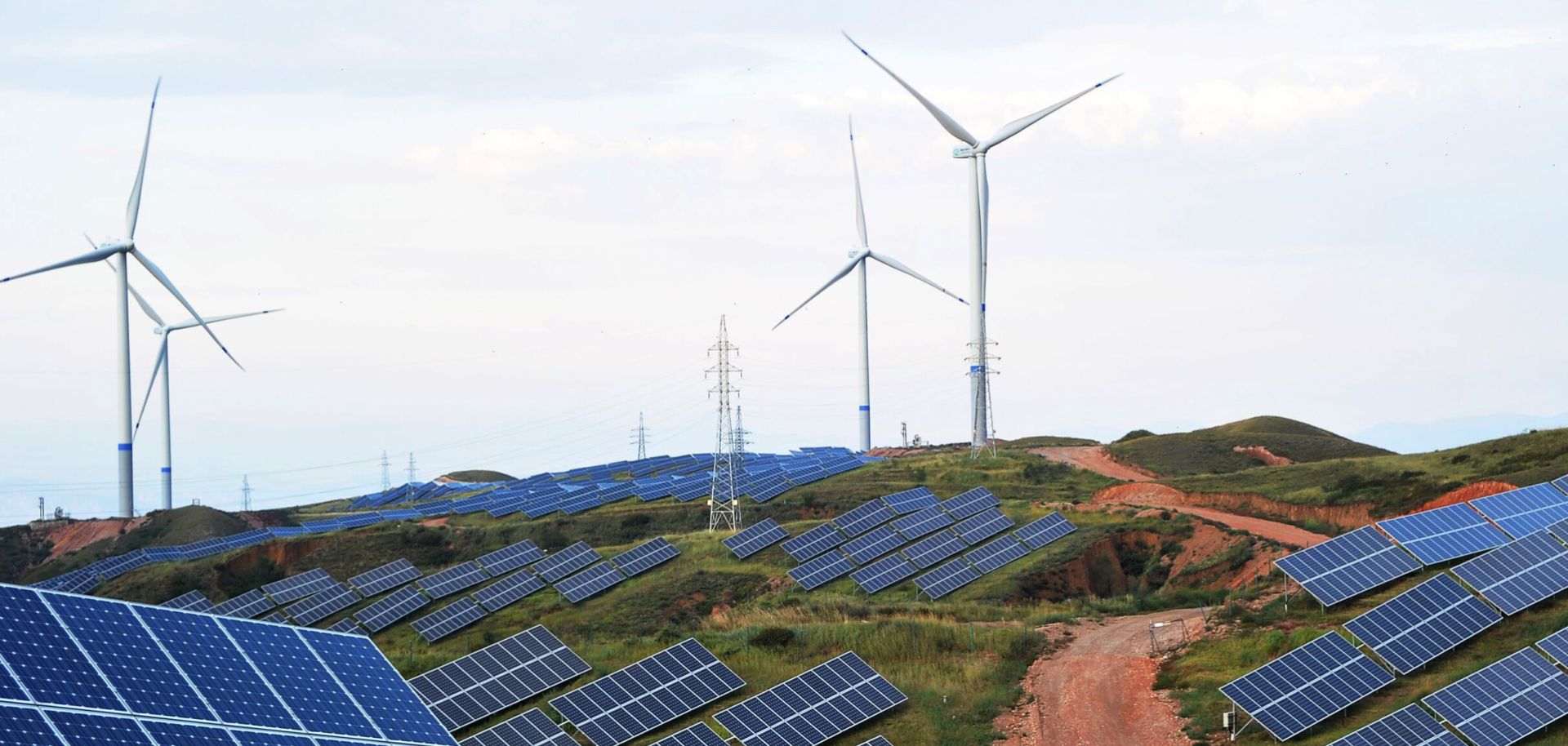 Solar panels and wind turbines are pictured on a barren mountain at Shenjing Village in 2018 in Zhangjiakou, Hebei Province of China.