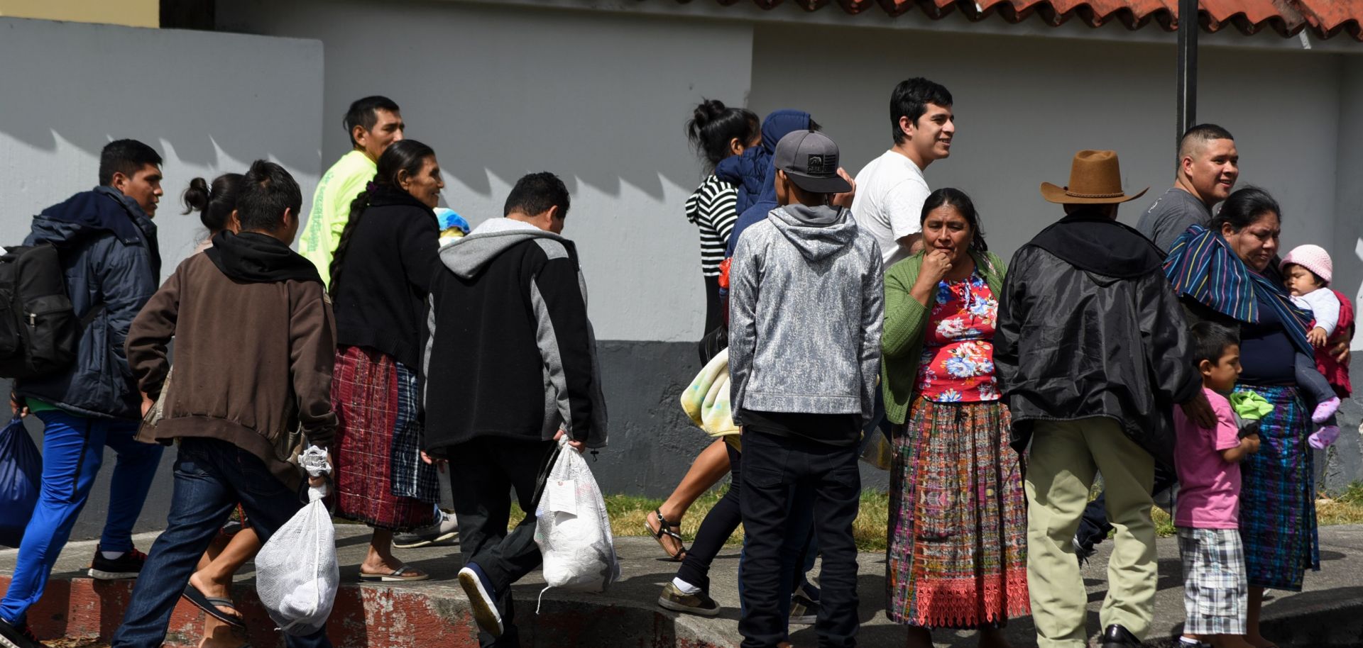 Migrants deported from the United States stand outside an air force base in Guatemala City on Dec. 12, 2019.