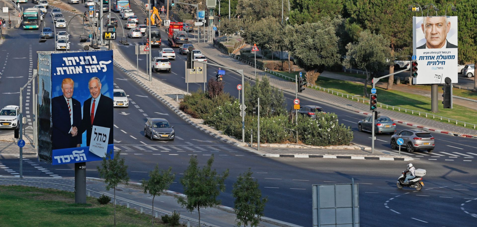 Election billboards for the Likud party and the Blue and White party line a street in Israel.