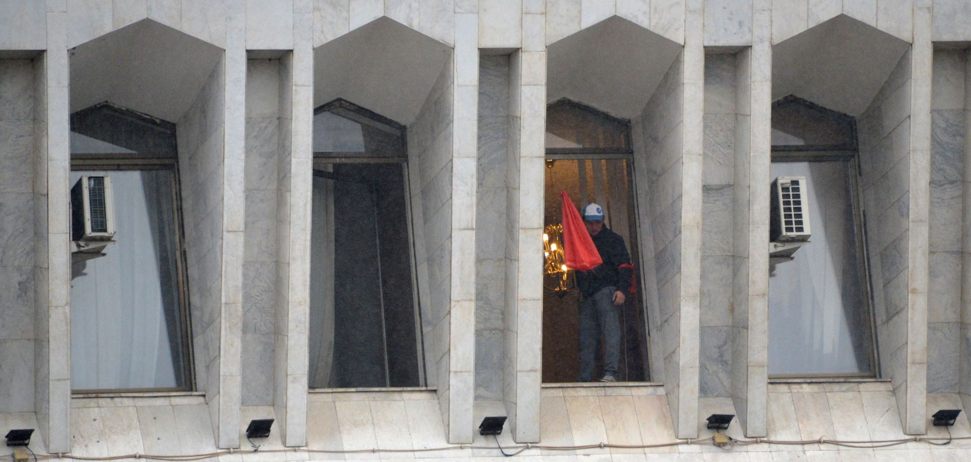 A protester is seen in the window of the seized main government building, known as the White House, in Bishkek, Kyrgyzstan, on Oct. 6, 2020. 