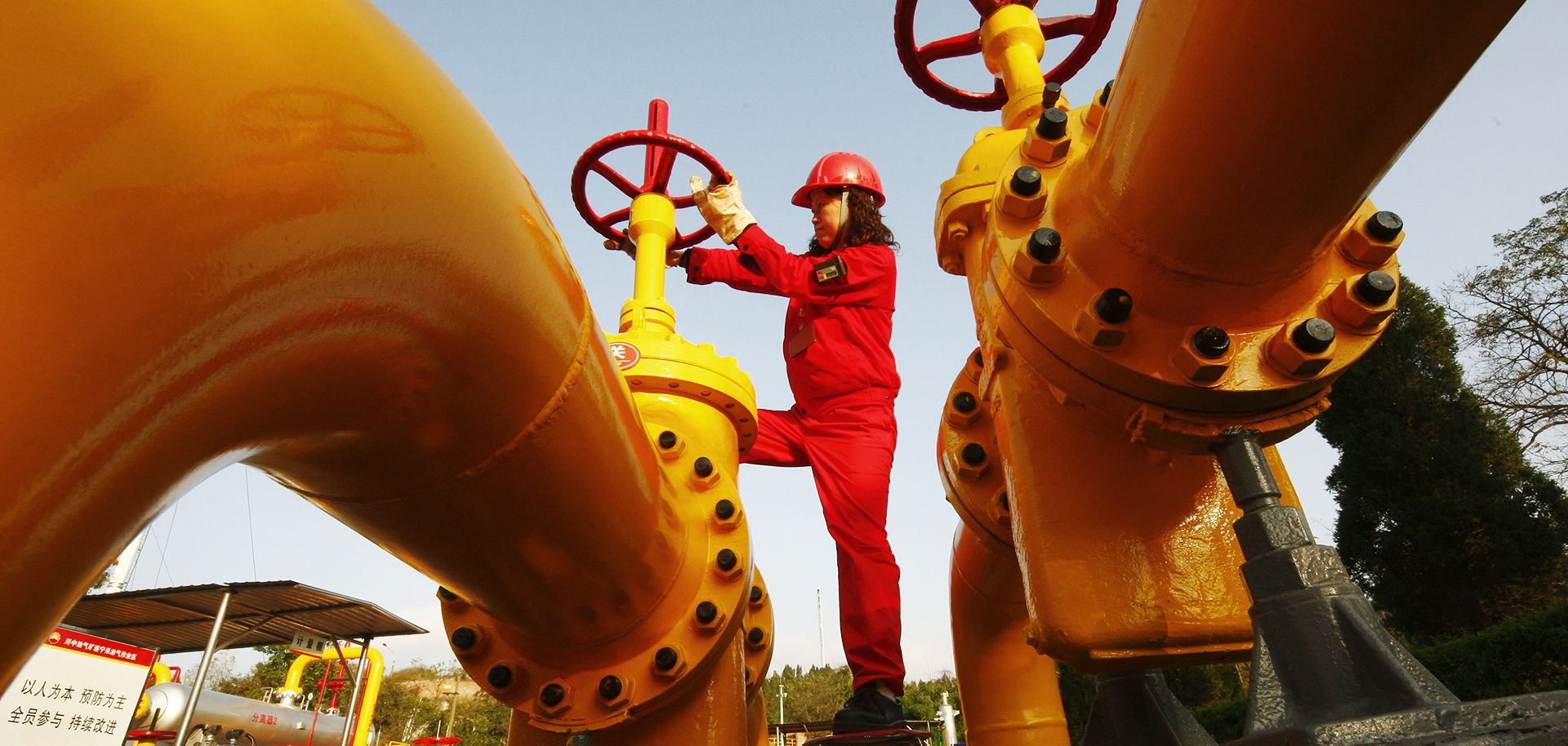 A Chinese worker checks a gas pipe valve at a natural gas plant in southwest China's Sichuan province.