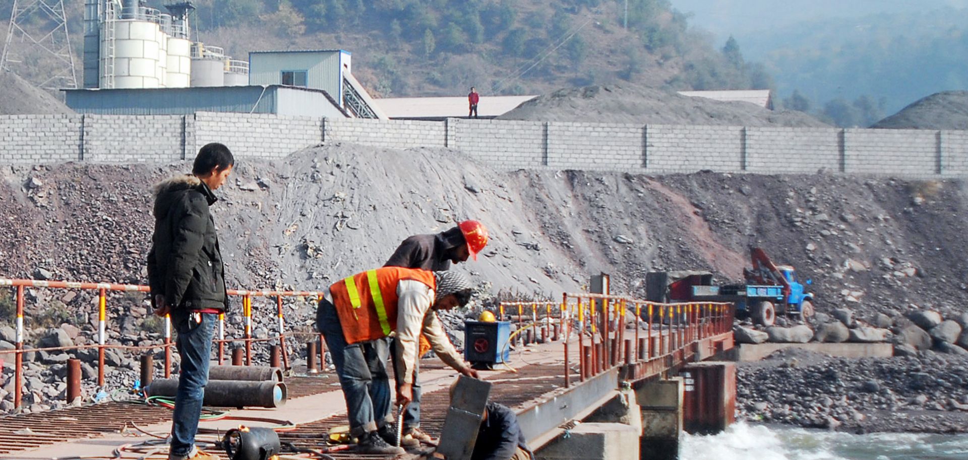 A Chinese engineer supervises workers building a bridge over a river near Muzaffarabad, the capital of Pakistani-administered Kashmir.