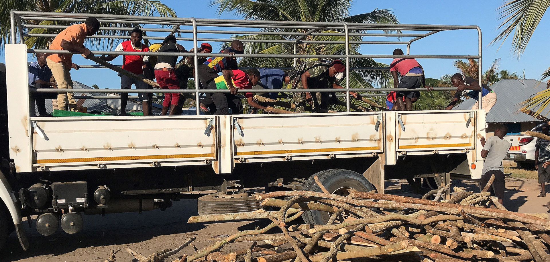 A picture shows internally displaced people and residents unload a truck with goods of first necessity, food and blankets in Naunde, northern Mozambique on June 13, after fleeing the recent attacks.