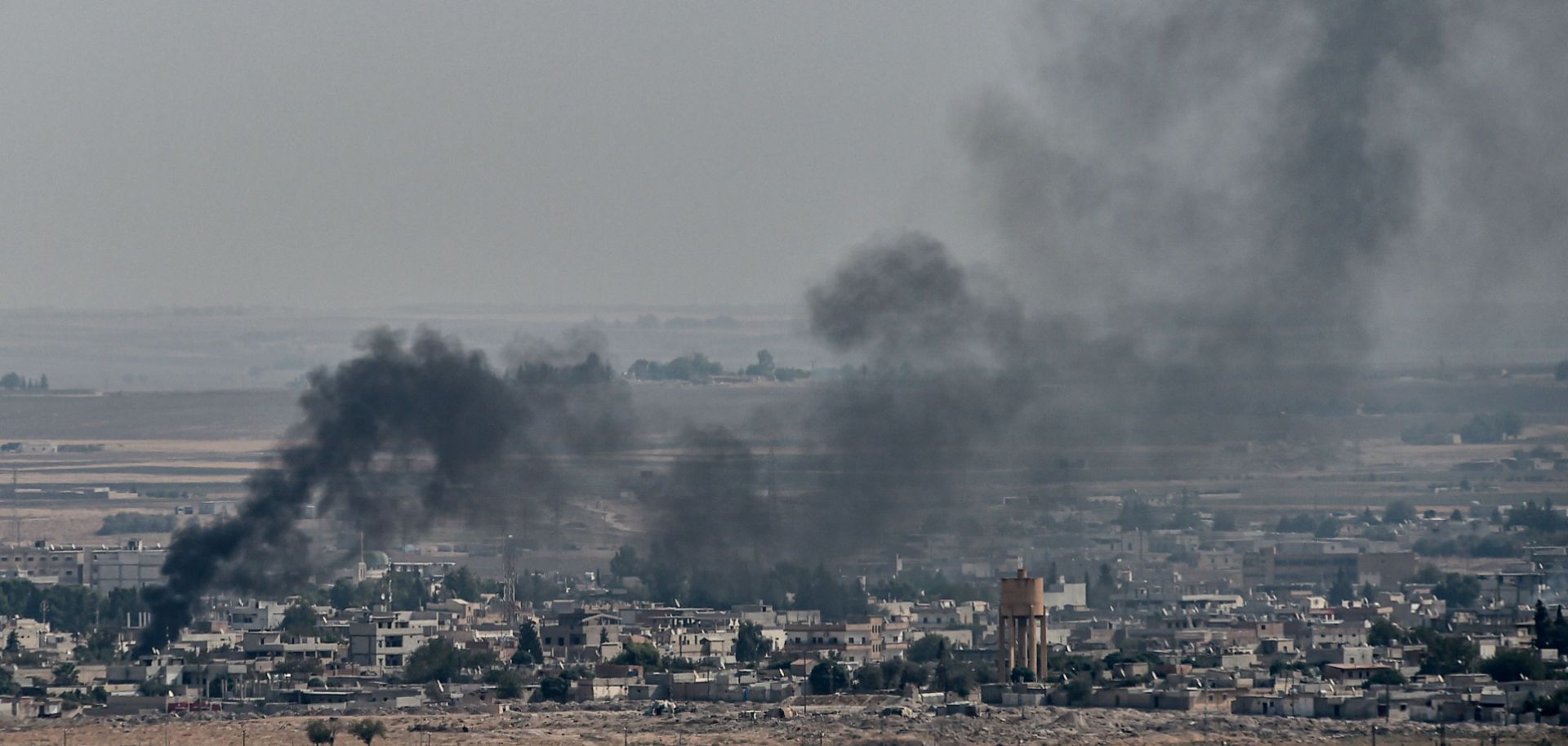 This photo shows smoke rising from the Syrian border town of Ras al-Ayn on Oct. 11, 2019, the third day of Turkey's military operation against Kurdish forces in northeastern Syria.