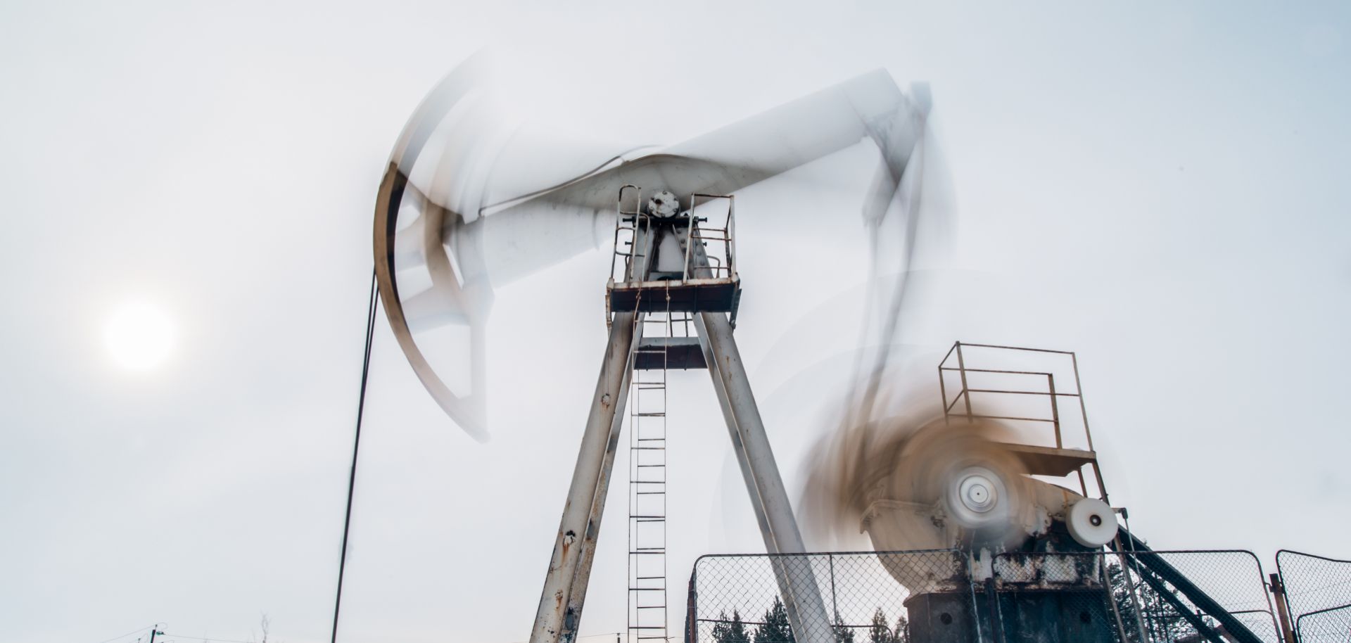 A photo of a pump jack extracting crude oil from a snow-covered well located near Surgut, Russia.