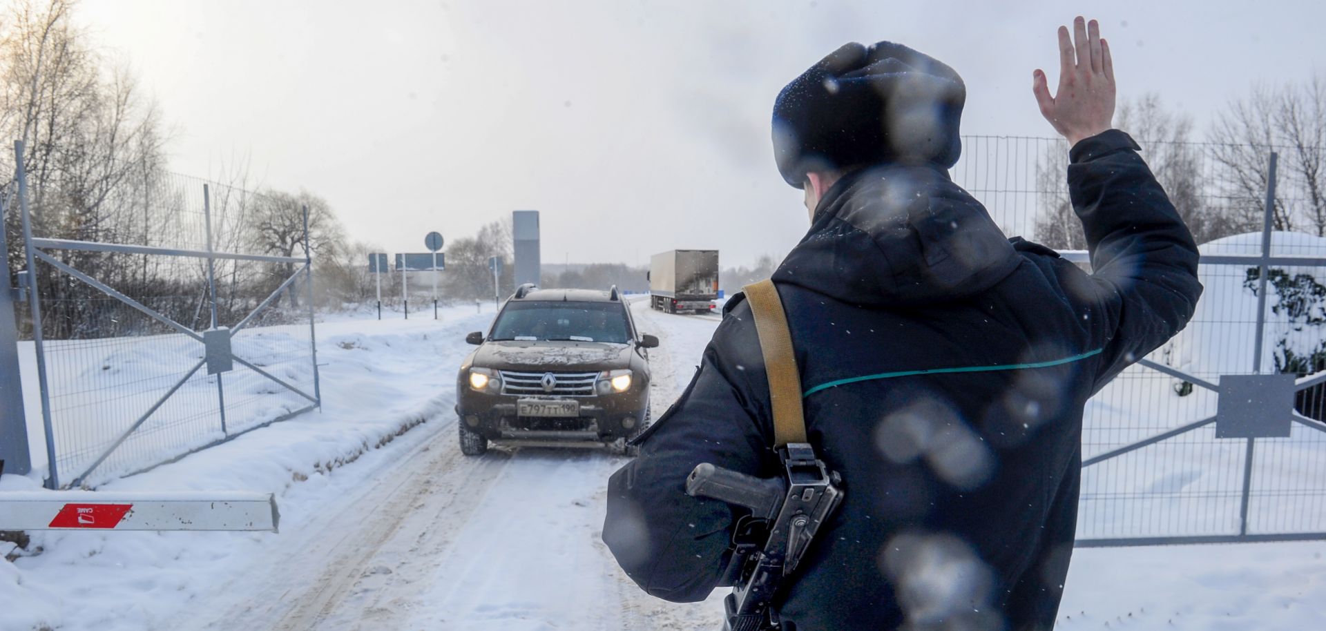 A guard stops a vehicle at Russia's Troyebortnoye border checkpoint on the Russian-Ukrainian border.