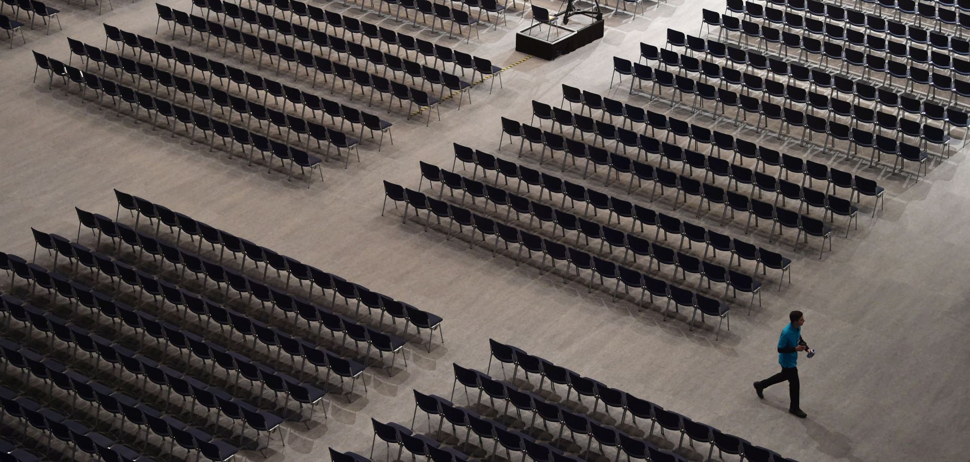 An employee walks between seats ahead of the Siemens company's annual shareholder's meeting.