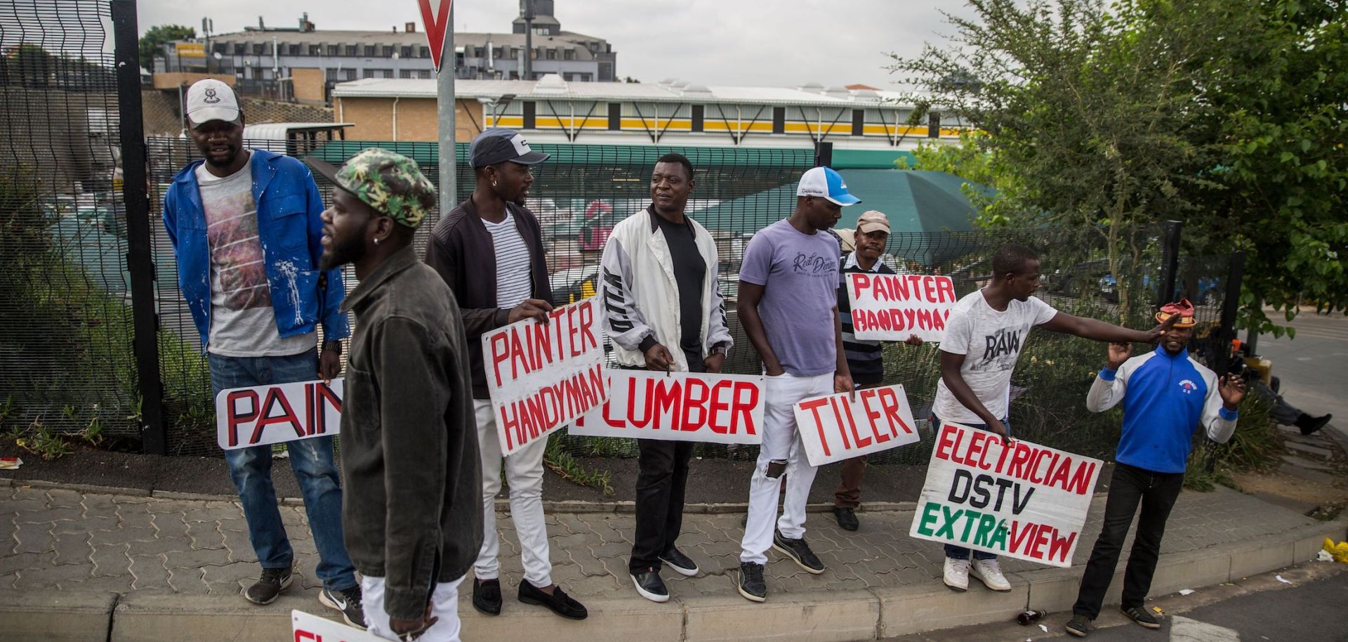 Tradesmen stand on the side of the road in Johannesburg, South Africa, seeking work.