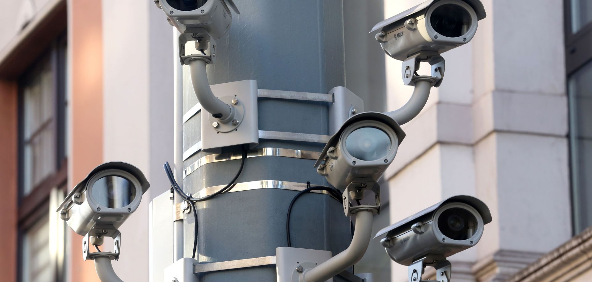 Five surveillance cameras on a lamppost.