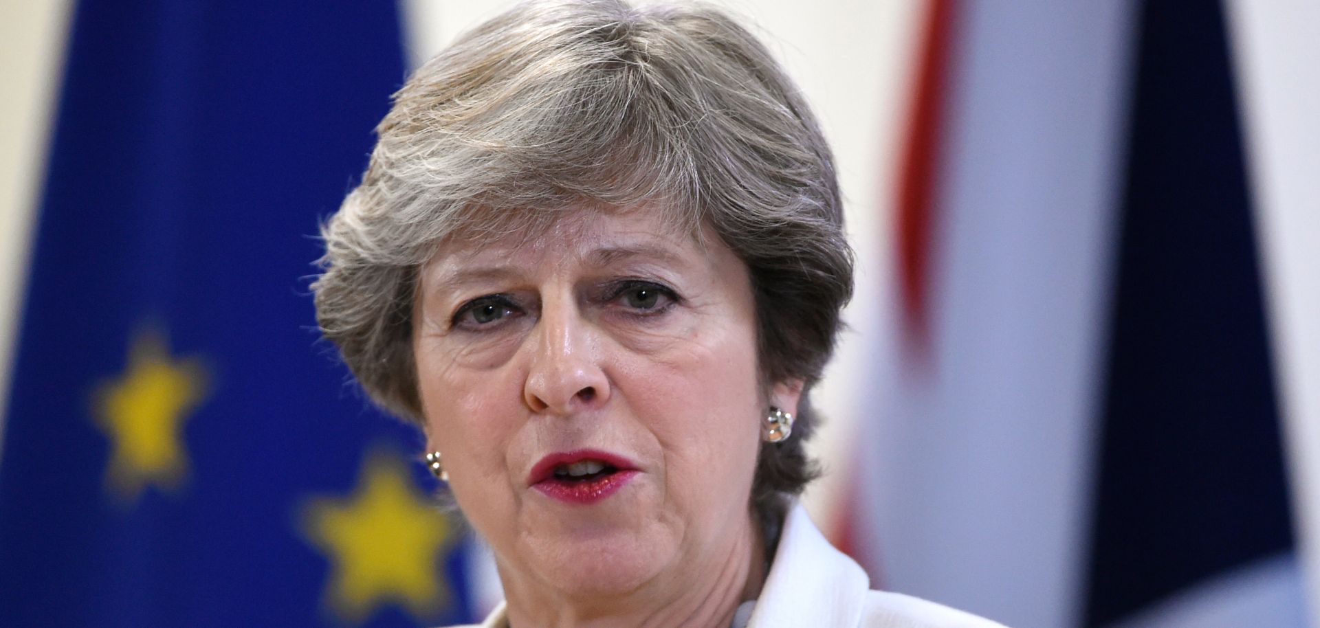 British Prime Minister Theresa May speaks to the press in front of U.K. and EU flags