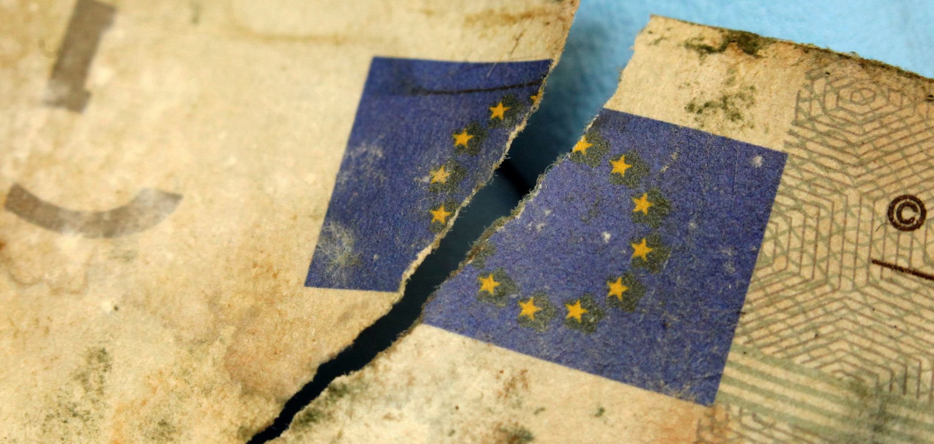 A German Federal Bank employee holds a flood-damaged five-euro banknote with the broken symbol of the European Union at the counterfeit analysis center in Mainz, Germany, on July 15, 2013.