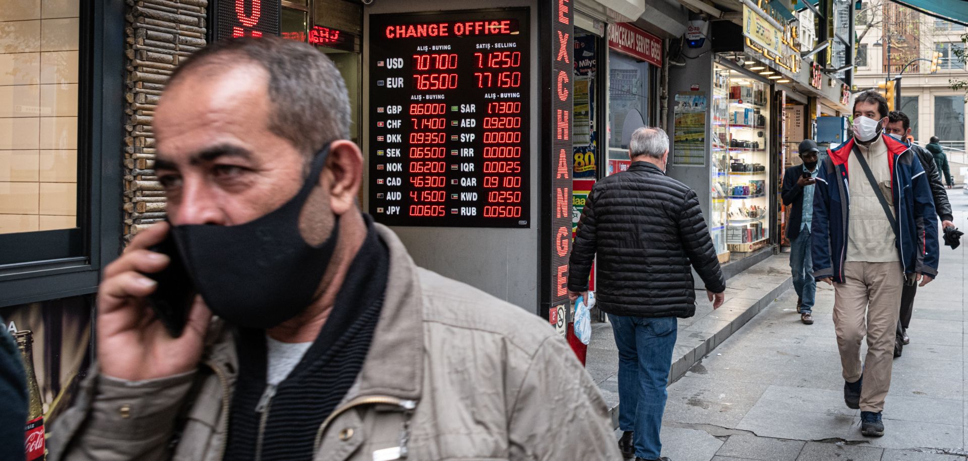 Pedestrians wearing masks walk down a street in Istanbul’s Eminonu district on May 5, 2020.