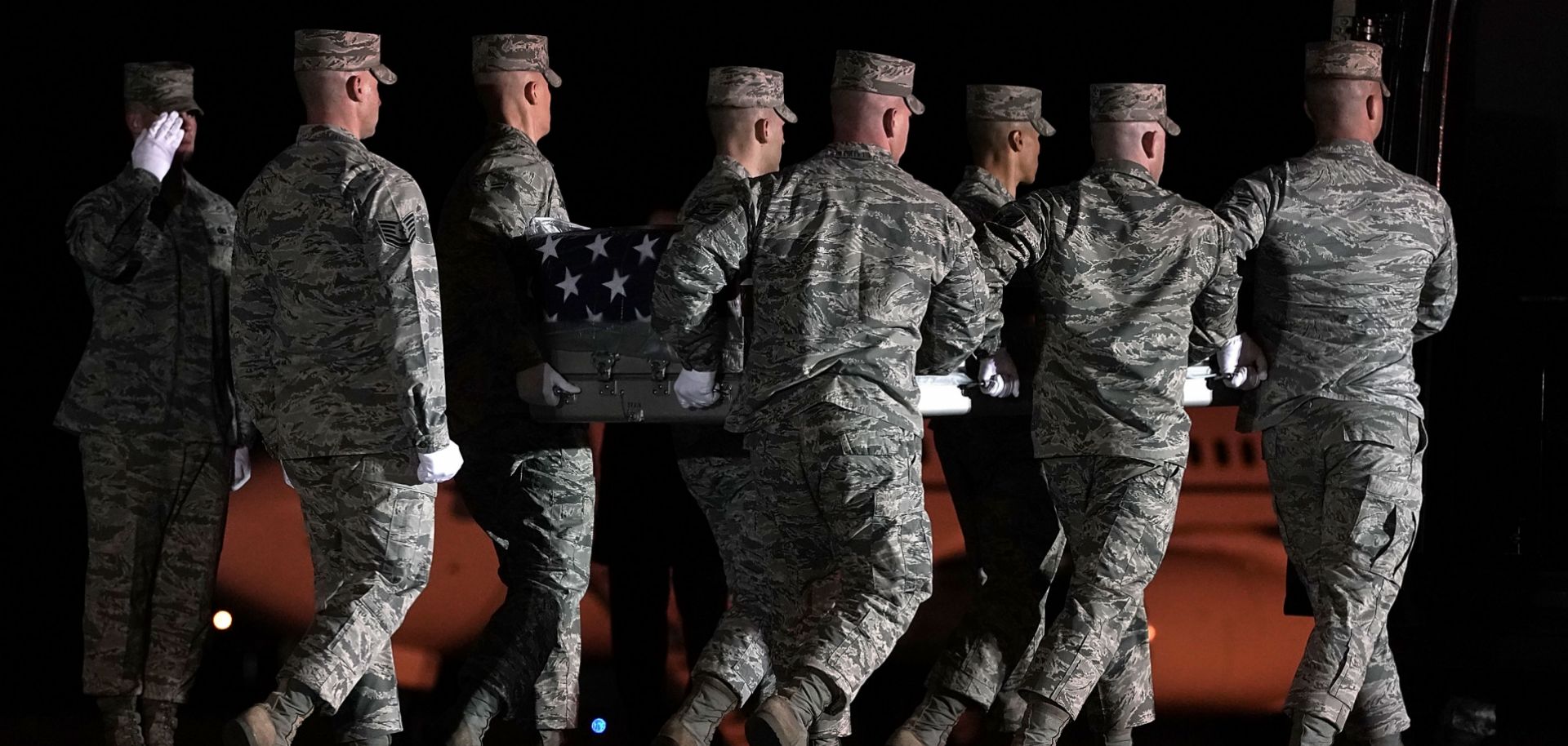 In this March 18, 2018, file image, members of the U.S. Air Force carry the flag-draped transfer case holding the remains of Air Force Master Sgt. Christopher Raguso of Commack, New York, at Dover Air Force Base in Delaware. Raguso was killed in a helicopter crash in western Iraq.