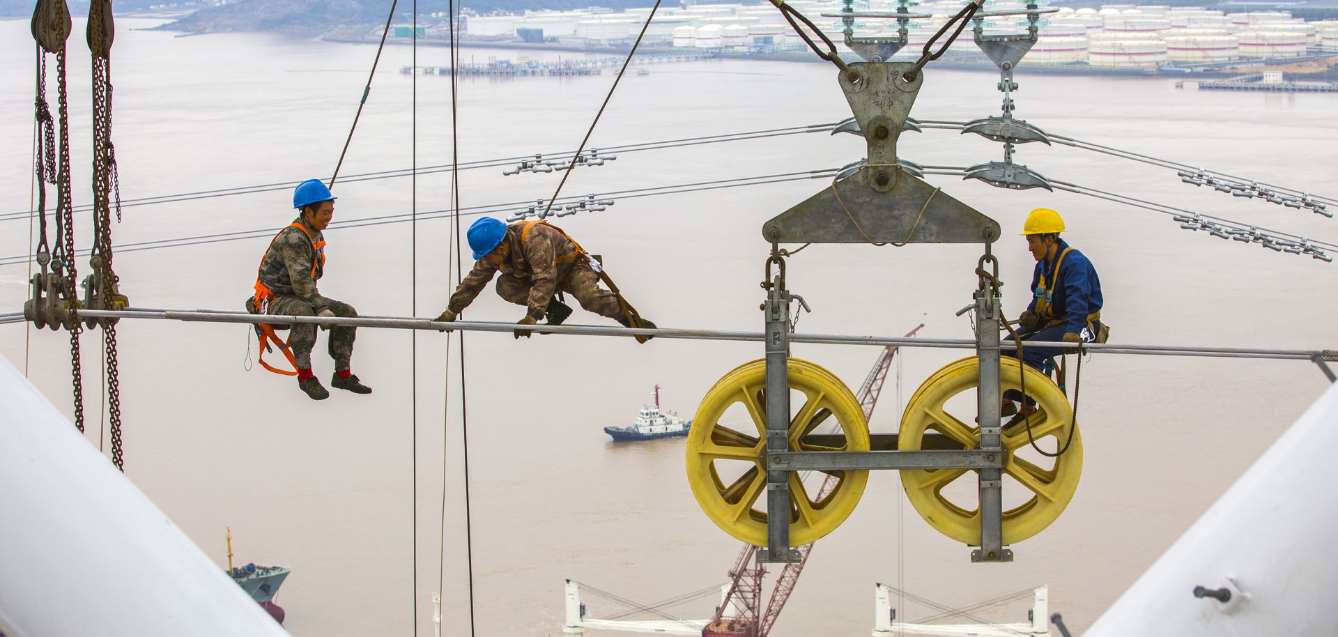 Workers assemble cables on a 500 kv high-voltage transmission tower.