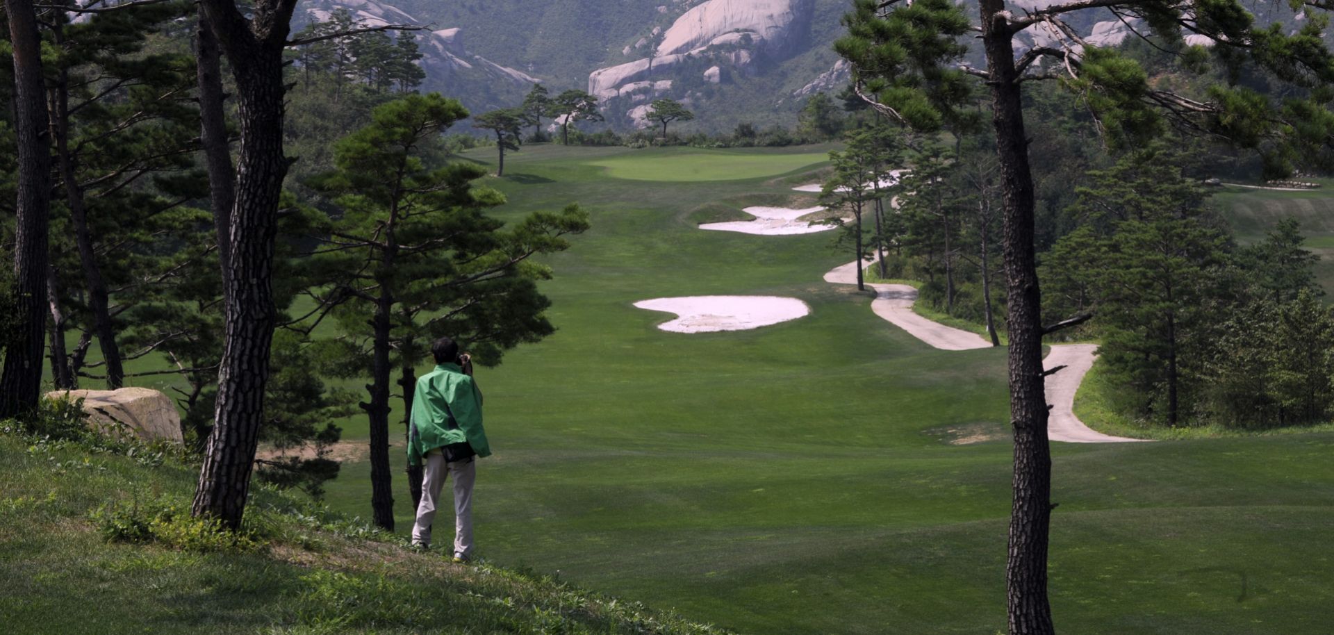 This photo shows a Chinese tourist photographing the derelict golf course at the shuttered Mount Kumgang resort in North Korea.