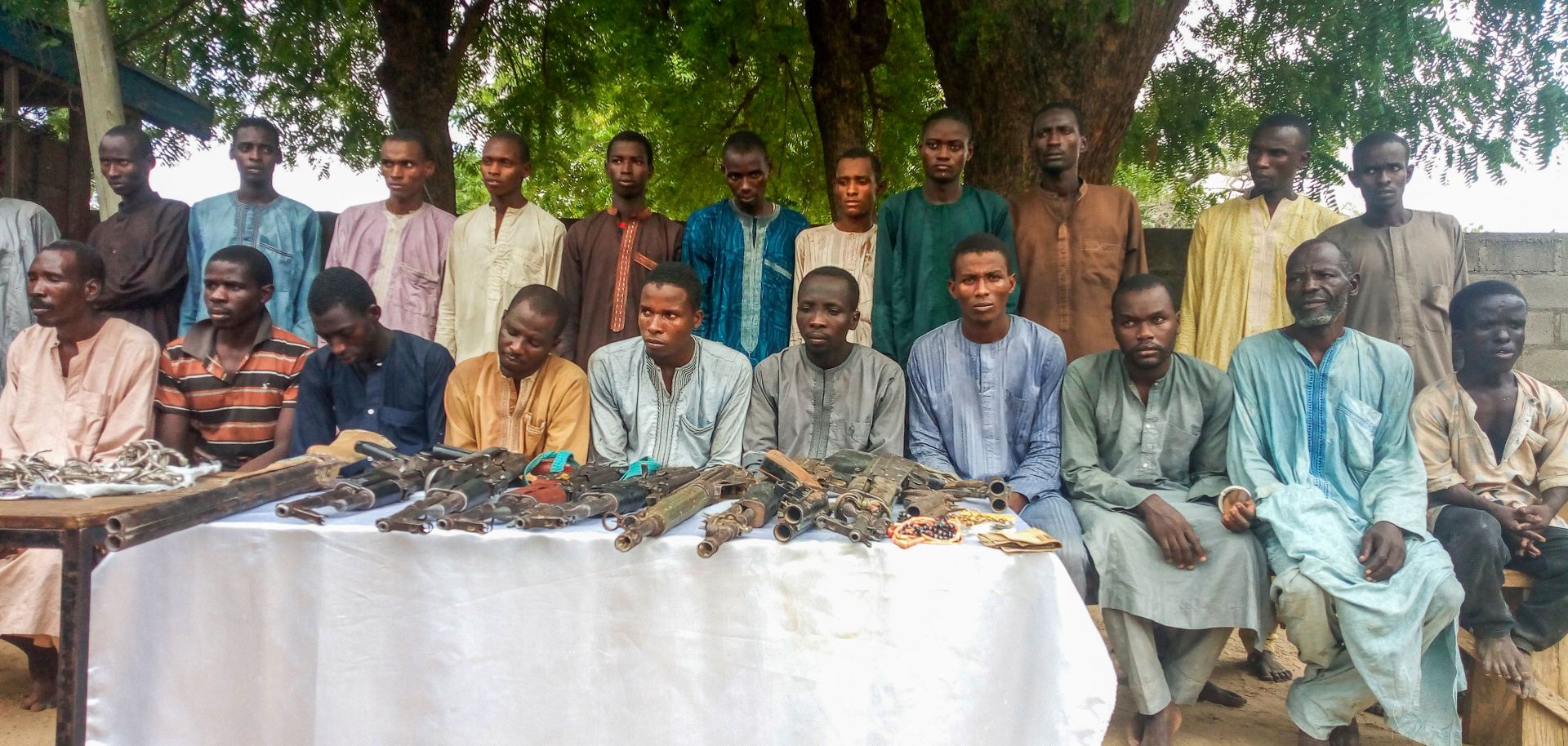Police officers present suspected ISWAP militants, as well as a cache of weapons, in Maiduguri, northeast Nigeria, on July 18.