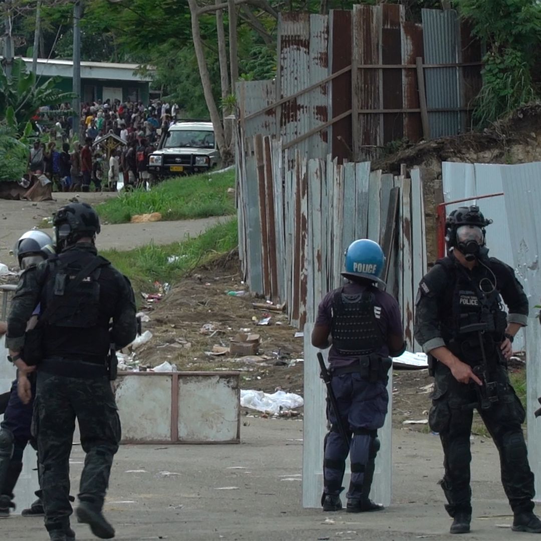 A frame grab from video footage shows Australian Federal Police officers and local police monitoring a crowd in Honiara, the capital of the Solomon Islands, on Nov. 26, 2021. 