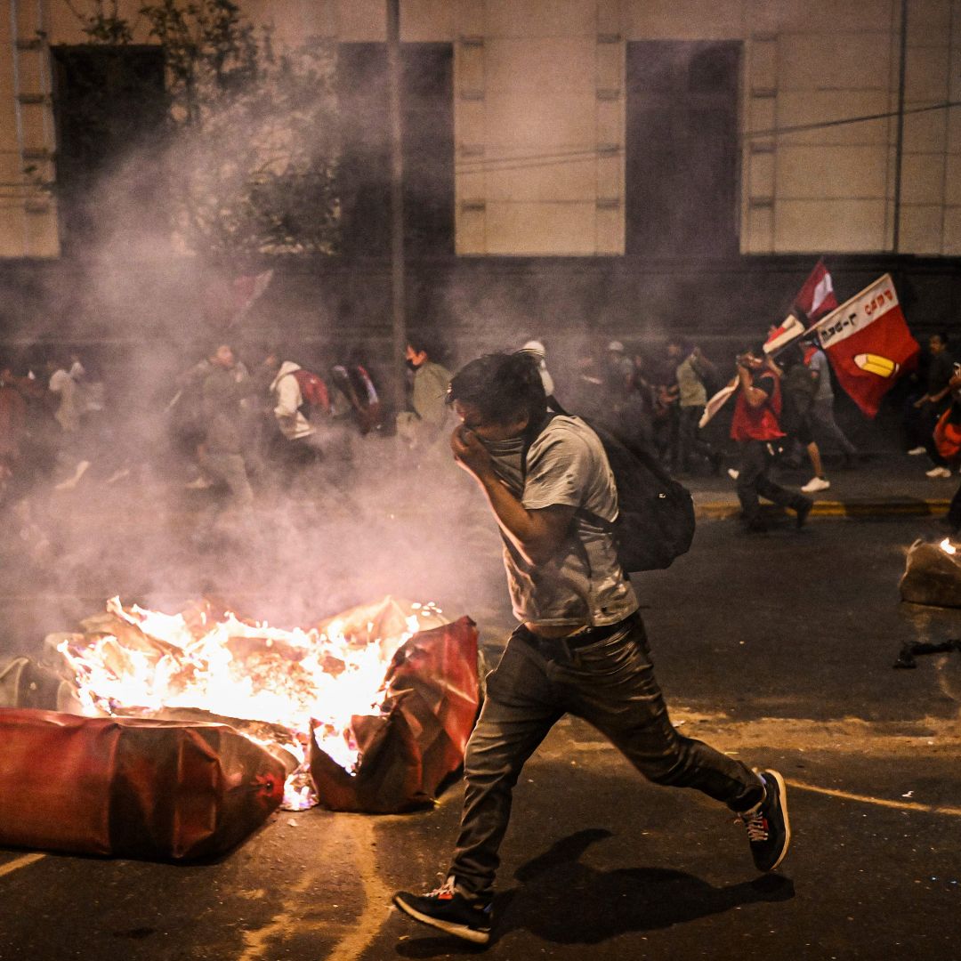 Supporters of former Peruvian President Pedro Castillo clash with riot police in Lima on Dec. 11, 2022, during a demonstration demanding Castillo's release and early legislative elections. 